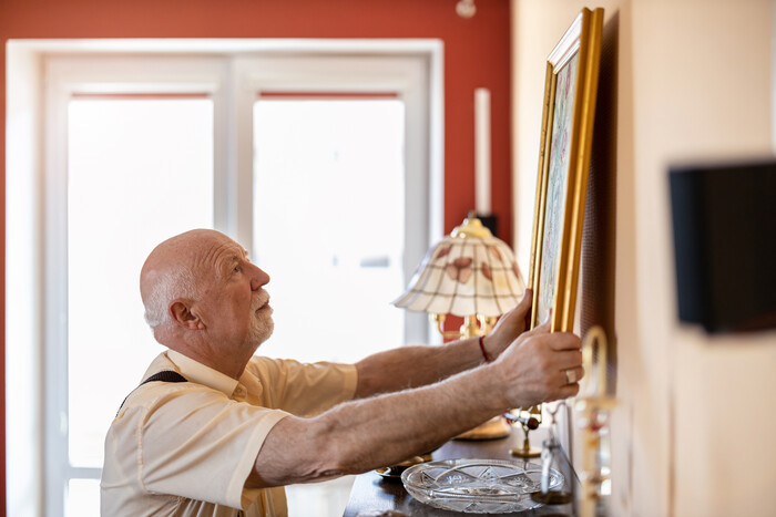 Senior hanging a picture on the wall